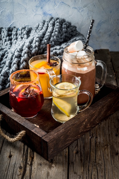 Sélection de diverses boissons traditionnelles d'automne: chocolat chaud à la guimauve, thé au citron et au gingembre