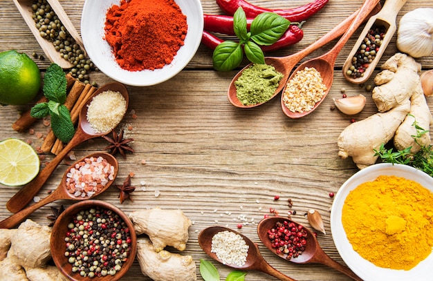 Une sélection de diverses épices colorées sur une table en bois dans des bols et des cuillères