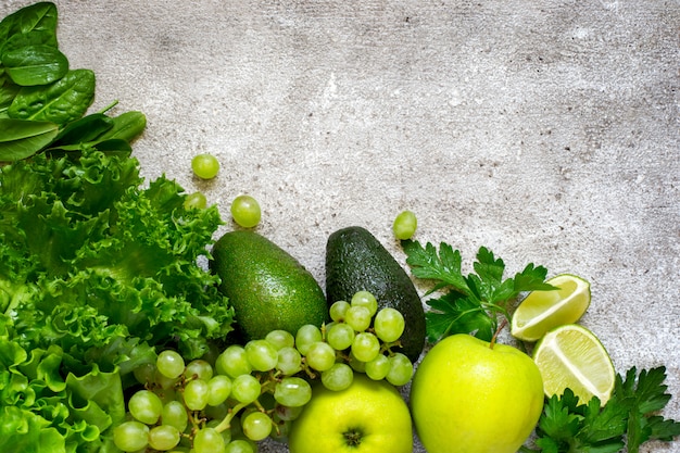 Sélection de fruits et légumes verts sur un dos de béton gris