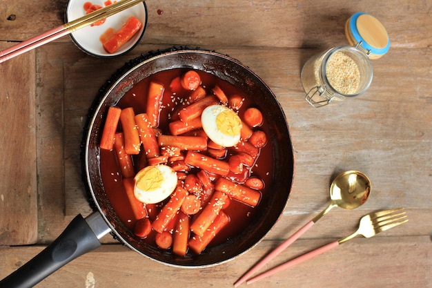 Selective Focus Topokki ou Tteokbokki est un gâteau de riz sauté avec des légumes et un gâteau de poisson dans une sauce épicée avec des graines de sésame, une cuisine de rue coréenne célèbre et populaire