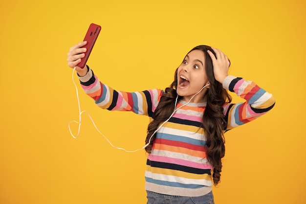 Selfie enfants Portrait d'une adolescente mignonne utilisant un téléphone portable discutant sur le web en tapant un message sms