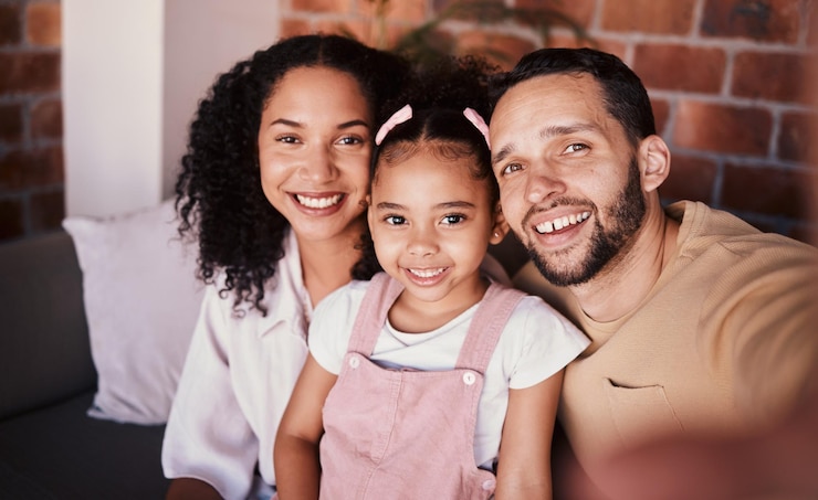 Photo selfie de famille dans le salon parents et enfants avec amour sourire et se détendre sur le canapé à la maison portrait de maman papa et fille sur le canapé dans l'appartement homme et femme heureux avec fille se liant ensemble