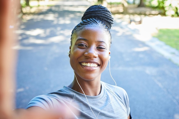 Selfie fitness et portrait d'une femme noire dans le parc avec le sourire pour les objectifs d'exercice course à pied et entraînement au marathon Photo sportive et visage d'une fille heureuse pour l'entraînement cardio corps sain et bien-être