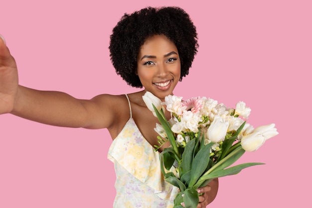 Photo selfie avec des fleurs d'une jeune femme afro-américaine