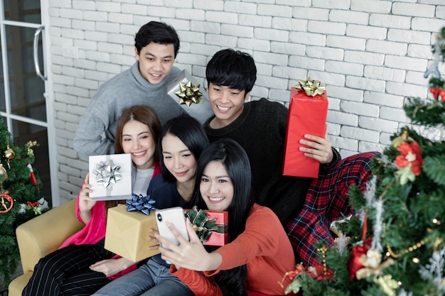 Selfie de groupe de jeunes asiatiques avec des cadeaux à la maison pour célébrer le festival de Noël. Les adolescents thaïlandais célèbrent Noël et le Nouvel An. Joyeux Noël et joyeuses fêtes.