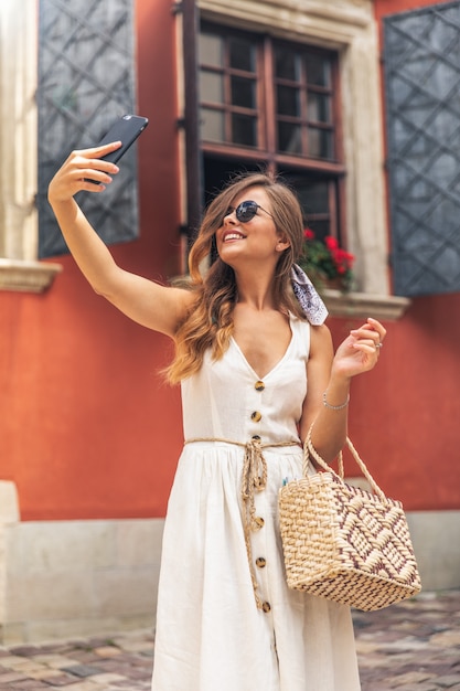Selfie Portrait d'une jeune femme dans la rue avec un smartphone