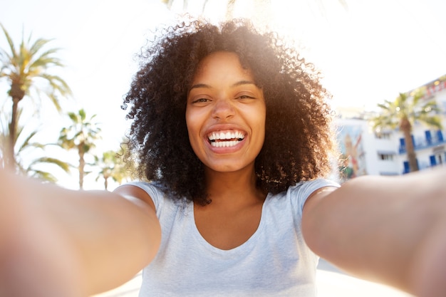Photo selfie de rire femme noire à l'extérieur avec des cheveux bouclés