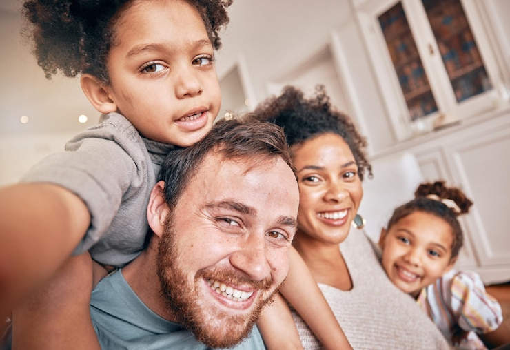 Photo selfie sourire et ferroutage avec une famille recomposée dans leur maison ensemble pour s'amuser en amour ou se rapprocher portrait heureux ou soutien avec les parents et les enfants posant pour une photo ludique dans une maison