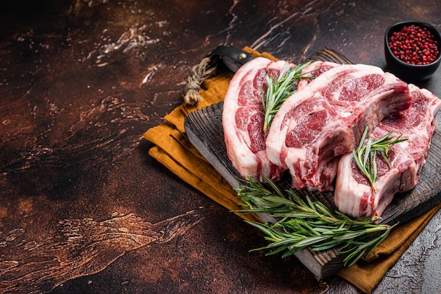 Selle fraîche crue de mouton d'agneau aux herbes et épices sur planche de boucher Fond sombre Vue de dessus Espace de copie