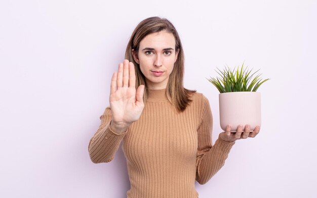 semblant sérieux montrant la paume ouverte faisant un geste d'arrêt