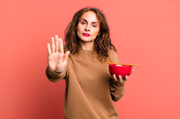 semblant sérieux montrant la paume ouverte faisant un geste d'arrêt