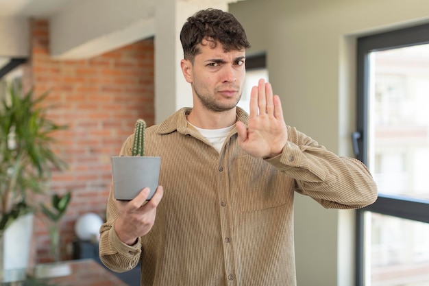 semblant sérieux montrant la paume ouverte faisant un geste d'arrêt