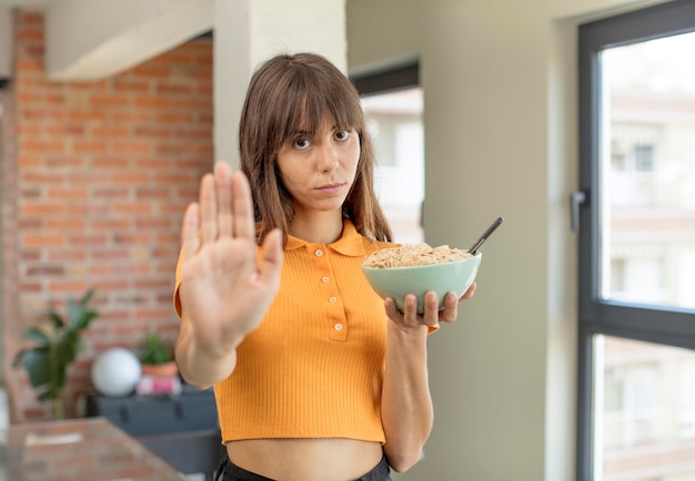 semblant sérieux montrant la paume ouverte faisant un geste d'arrêt