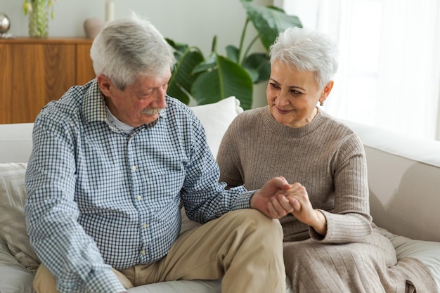 Senior adult mature couple in love holding hands at home mi-âge mari et femme à la recherche avec t