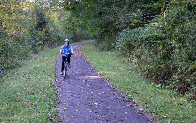 Senior adult woman cycles vers la caméra