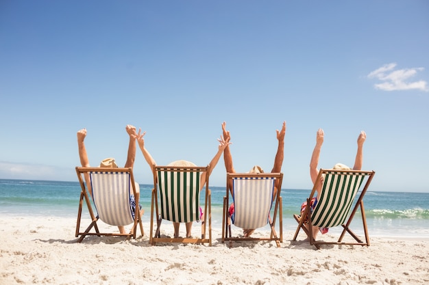 Senior amis assis sur une chaise de plage