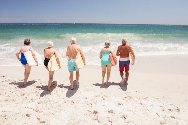 Senior amis tenant une planche de surf