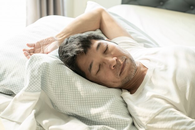 Senior asiam homme dormant sur le lit