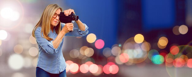 Senior belle femme avec une caméra de cinéma vintage