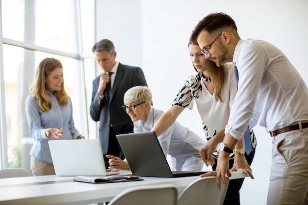 Senior businesswoman travaillant avec de jeunes gens d'affaires au bureau