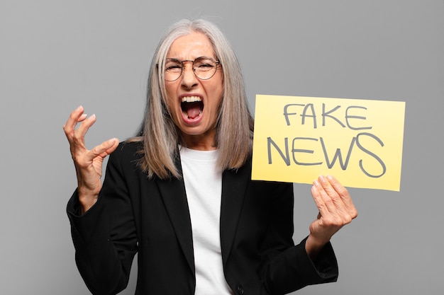 Senior businesswoman with fake news banner