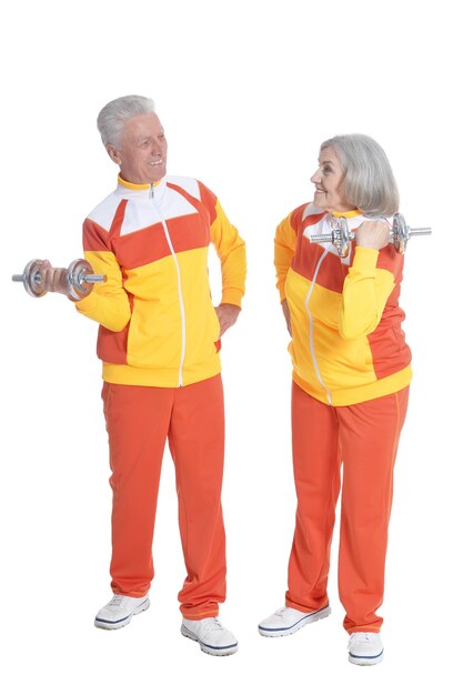 Senior Couple exerçant avec des haltères sur fond blanc