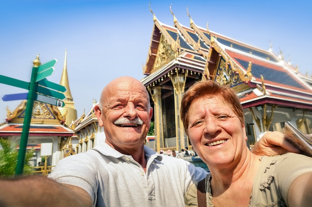 Senior couple heureux prenant un selfie dans les temples du Grand Palais à Bangkok