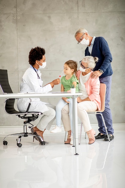 Senior couple avec jolie petite-fille noire femme médecin au bureau