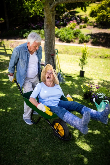 Senior couple jouant avec une brouette