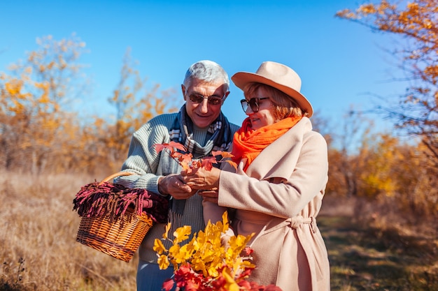 Senior couple marchant dans la forêt d'automne.