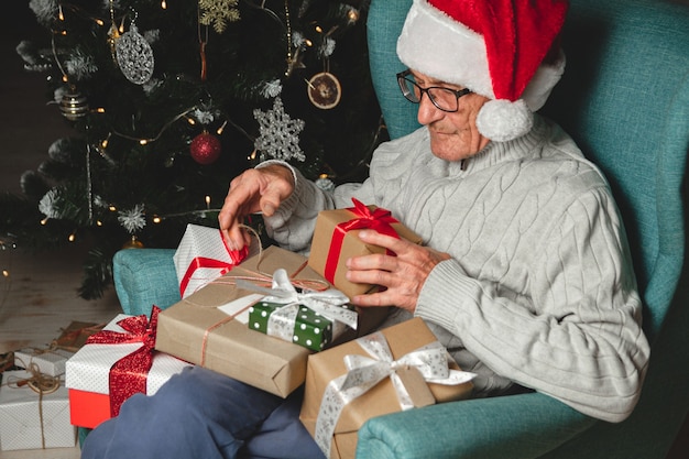 Senior Dans Un Chapeau De Père Noël Avec Beaucoup De Cadeaux De Noël