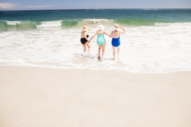 Senior femme amis courir dans l'eau