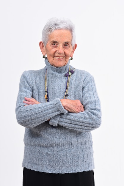 Senior femme aux bras croisés sur fond blanc