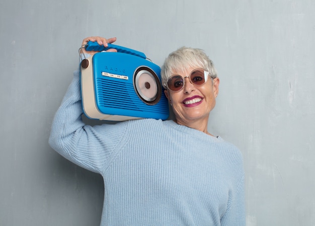 Senior Femme Cool Avec Une Radio Vintage, écouter De La Musique Contre