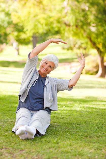 Senior femme fait ses étirements dans le parc