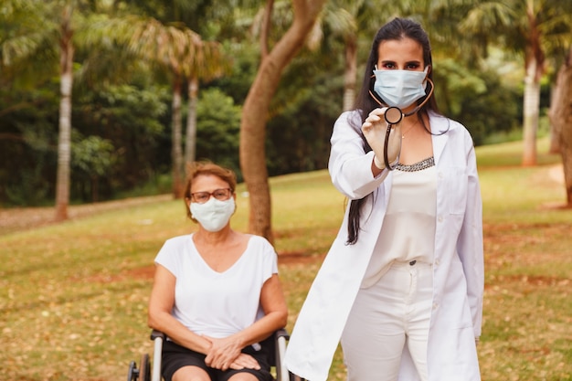 Senior femme handicapée avec soignant dans le jardin de la maison de soins infirmiers