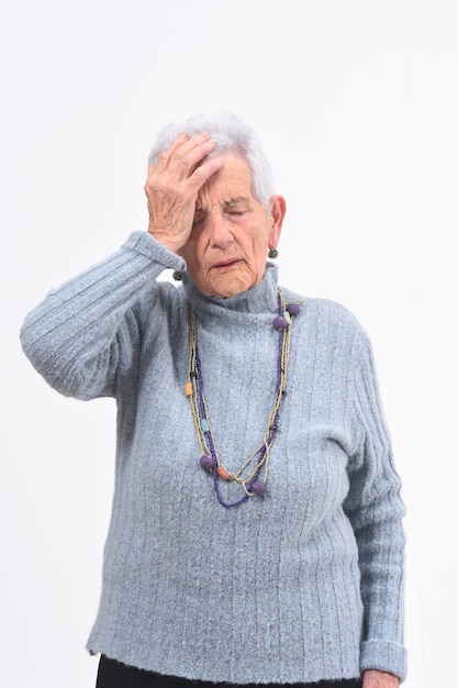 Senior femme avec mal de tête sur fond blanc