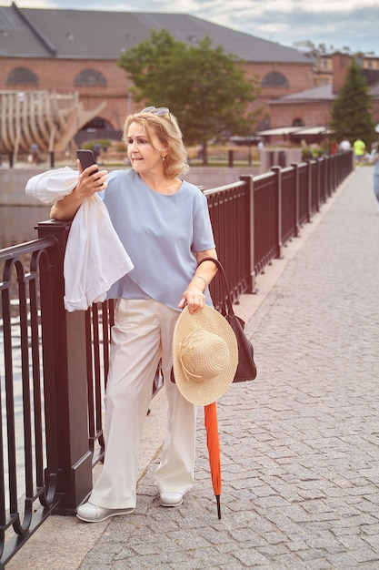 Senior femme séduisante caucasienne d'environ 60 ans marche.