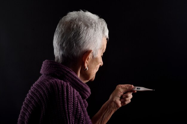 Senior femme avec thermomètre