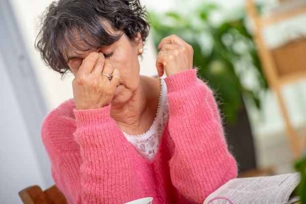 Senior femme avec les yeux maux