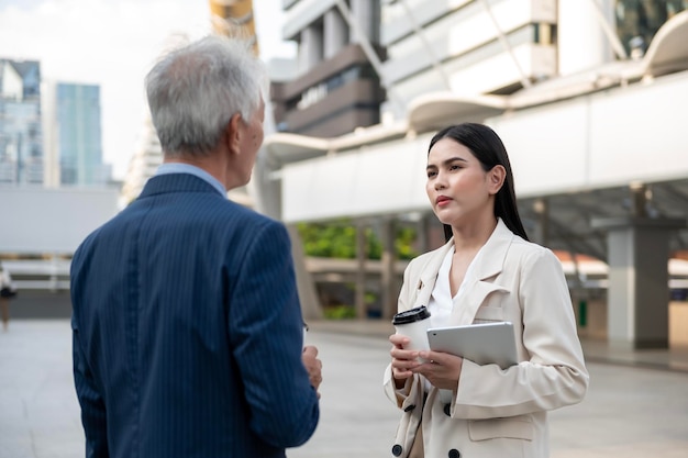 Senior homme d'affaires d'âge moyen mature asiatique et jeune femme d'affaires ayant une discussion