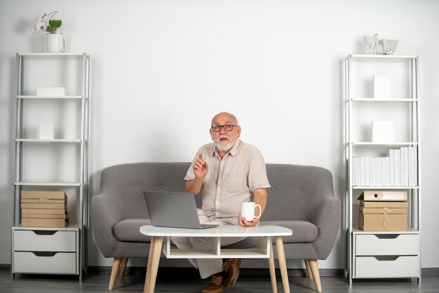 Senior homme âgé mature regardant un webinaire en ligne de formation commerciale sur un ordinateur portable travaillant à distance ...