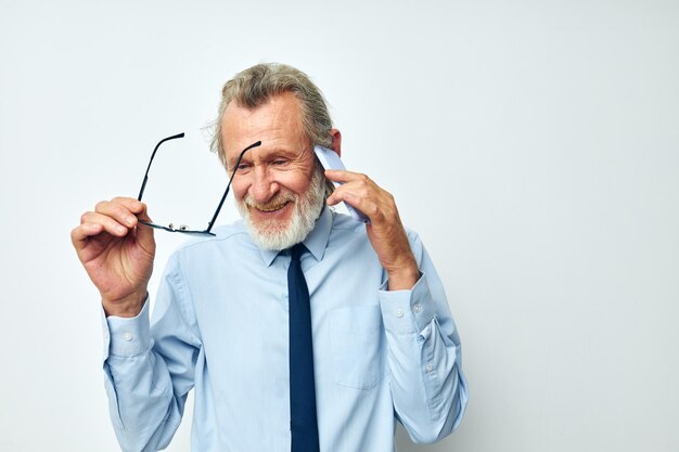 Senior homme aux cheveux gris parlant au téléphone travail d'affaires fond isolé