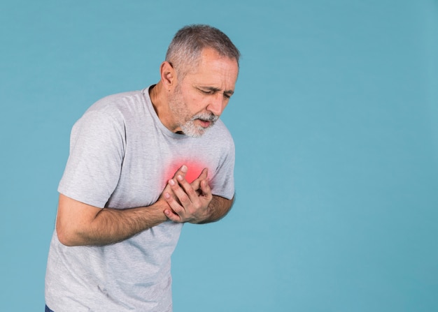 Photo senior homme ayant une douleur à la poitrine sur fond bleu