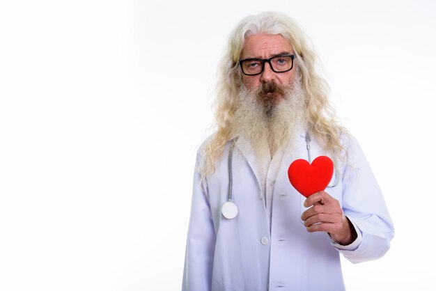 Senior homme barbu médecin tenant coeur rouge