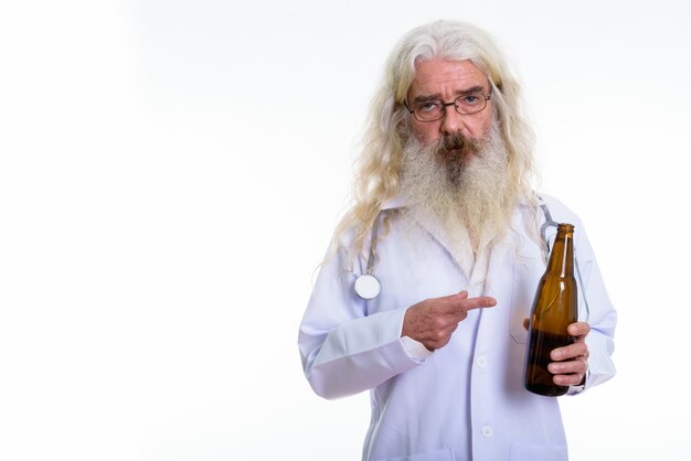 Senior homme barbu médecin tenant et pointant sur la bière