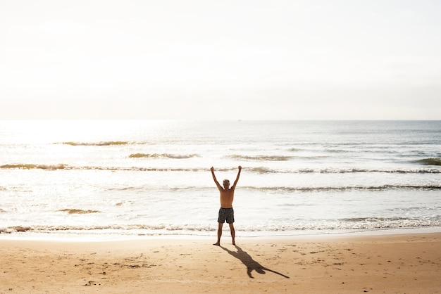 Senior homme caucasien debout à la plage