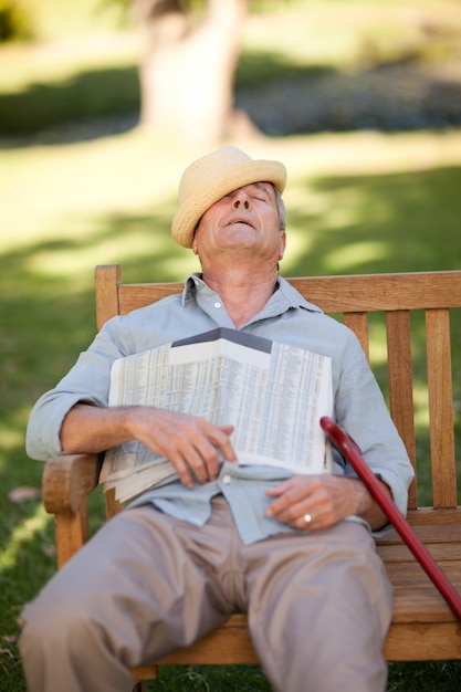 Senior homme dort sur le banc