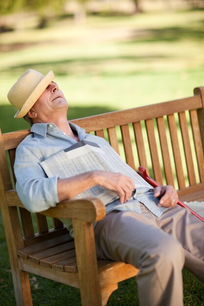 Photo senior homme dort sur le banc