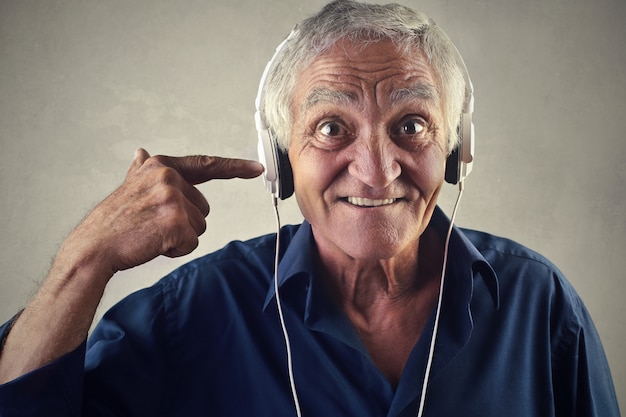 Senior homme écoutant de la musique sur des écouteurs